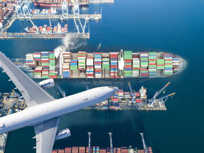 集装箱船舶和运输飞机在进出口业务和物流国际货物。用起重机将货物运到港口。鸟瞰图和俯视图。照片摄影